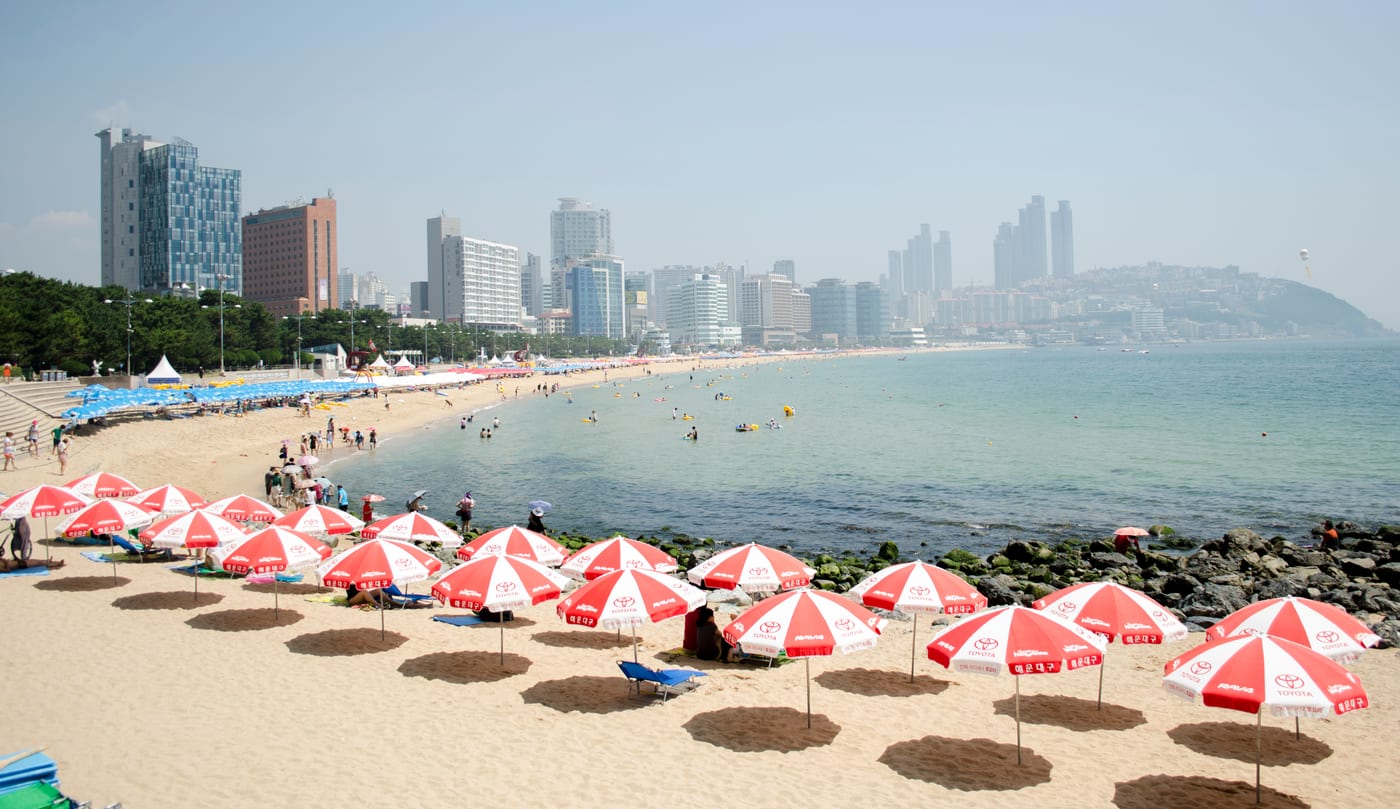 Parasols on Haeundae Beach with the waterfront skyline beyond