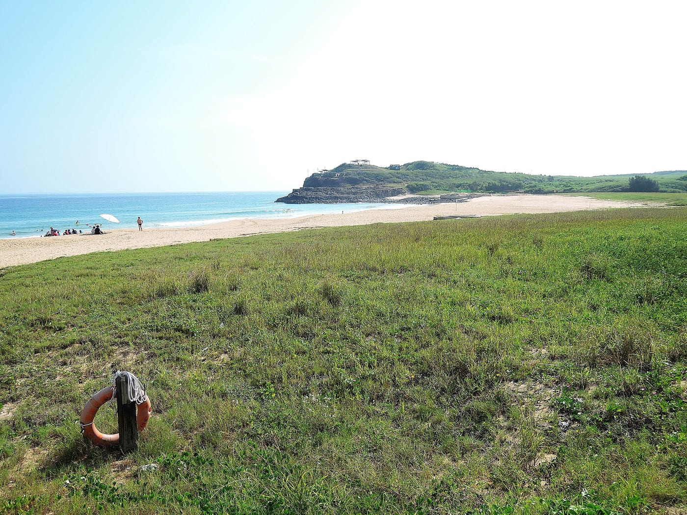 Grassland, sand and blue sea beside Shanshui Beach