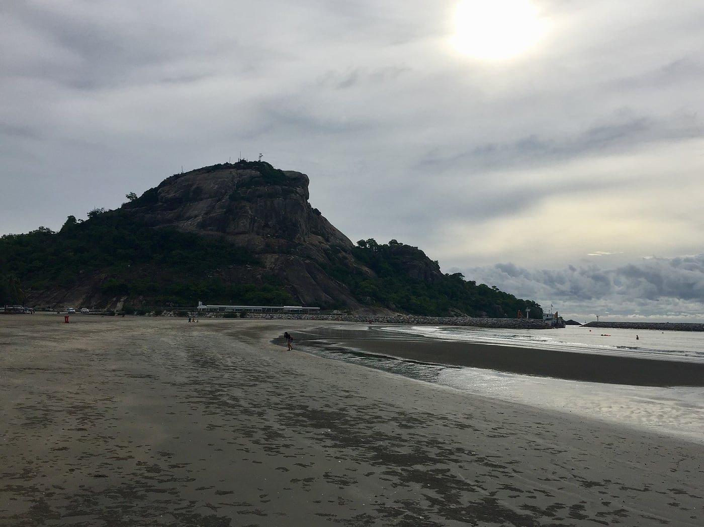 Khao Takiab hill and exposed sand along the beach beneath a cloudy sky